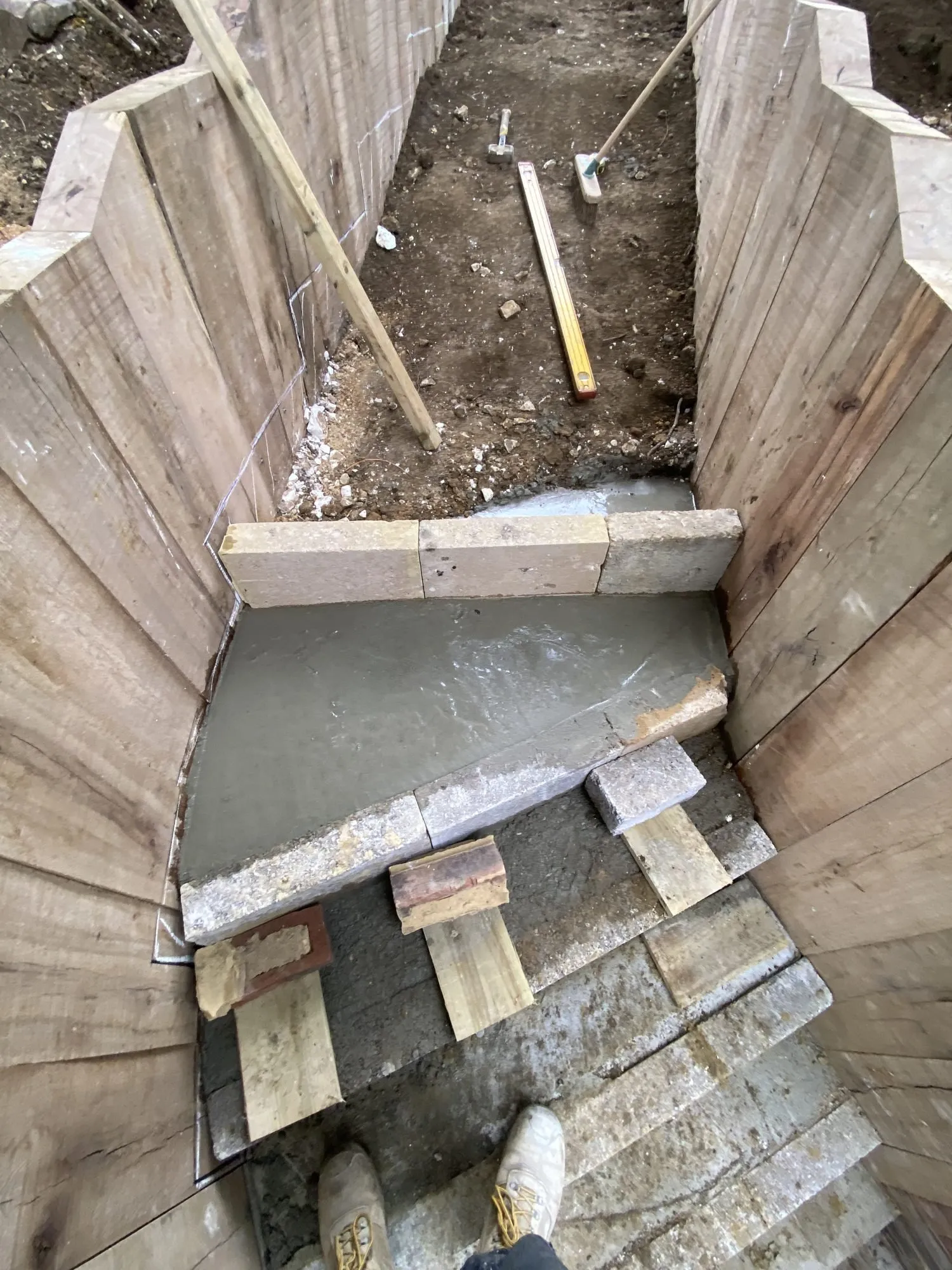 Freshly poured concrete step between upright oak sleepers on a hillside in Brighton and Hove